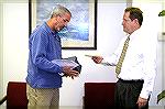 S.T.O.P. (Stop Taxing Ocean Pines) representative Michael Borland (left)presents petition containing over 900 lot owner signatures to OPA Board Secretary Reid Sterrett which "demands that the Board of