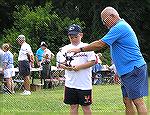 Youngster is assisted with casting technique by Ocean Pines Anglers Club member 6/26/2004.