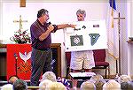 Denny Bowers shows audience the plans for the Worcester County Veterans Memorial at Ocean Pines during Sea Chanters concert at Community Church at Ocean Pines on 8/15/2004.