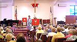 Roseann Bridgman, co-chair of the Worcester County Veterans Memorial at Ocean Pines explains plans to the audience during a break in the Sea Chanters performance on 8/25/2004.