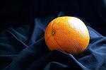 Photo of orange taken inside on a black cloth, near a window.  Camera on a tripod, no flash, shutter speed 1/8 sec at F/4.5.