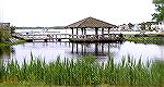 Scene at Swim & Racquet Club. Lagoon in foreground is area to be partially filled to "help" environment. Area in front of gazebo and to left will be filled with slips.