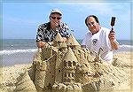 Photo of Mark Venit (right) and Jack Barnes, host of Focus on the Pines, during a video shoot on the beach of a sand castle building demonstration by Master Sand Sculptor and OPA Board member Mark Ven
