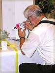 A member of the Ocean Pines Camera Club gets a photo of a flower at the Worcester County Garden Club show at the Ocean Pines Library on 10/10/2005.  Photo with an Olympus C-750 camera set for ISO 100,