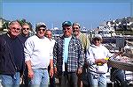 George Wood stands next to wife Jane who is fileting his 25&quot; Flounder. The fish was the winner in the OP Anglers Club annual Flounder Frenzy. Other OP Anglers are seen trying, unsucessfully, to p