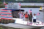 Bob Abele and Jim Coyne with a couple of hot chicks salute onlookers as Capt. Dave Lloyd pilots them by the reviewing stand in the OP Boat Clubs annual Boat Parade.  