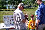 Budding angler Emmit Heeg and his Dad get some tips from an Ocean Pines Angler club member on the proper selection of lures. 