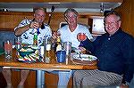 Jack Barnes and Dr John Bower of Ocean Pines along with Hunter the Undertaker enjoy a gourmet Italian dinner prepared aboard their chartered Hunter 44 by fellow skipper Rich Weinstein. 