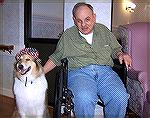 Therapy dog King celebrates 4th of July at the Berlin Nursing Home. Super puzzle maker & resident Manny poses for a photo with King.
