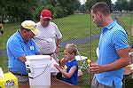 Young Phillip Meier and his friend John Gross listen carefully as Ken McMullen and Roger Baumgarten explain the finer points of fish handling at the 2009 Ocean Pines Anglers Club, Teach A Kid To Fish 