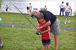 Angler Bill Bundy teaches aspiring young angler David Couvillton a few casting techniques at the Anglers Club annual Teach A Kid To Fish event.