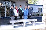 The members of the Ocean Pines Garden Club "bench committee" and the incoming president of the OPGC try out one of the newly installed granite benches in front of the community center.