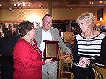 Marie Gilmore, outgoing president of the Worcester County Veterans Memorial at Ocean Pines, presents a plaque of appreciation to Ed and Margaret Colbert of Deer Run Golf Course for asistance with a fu