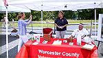 Mary Beth Carozza takes photo of Marie and Bob Gilmore manning the OP Veterans Memorial table at the Chamber of Commerce Classic Car Show.