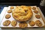 Apple pie surrounded by oatmeal raisin and chocolate chip cookies
