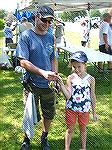 Anglers Board of Director Mike Vitak presents his custom rod to drawing winner Anastasia Bakie at the 2019 Anglers Club Art Hansen Youth Fishing Contest.
