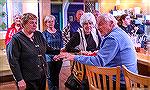 Marie Gilmore presents gift to outgoing Memorial Board member Steve Zangwill at appreciation party for volunteers helping the Worcester County Veterans Memorial at Ocean Pines hosted by Denovo's Tratt