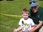 Ocean Pines Angler Club member Doug Murphy shows young angler how to cast.