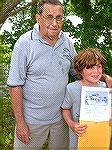 Art Hansen Memorial Youth Fishing Contest chairman Lee Phillips presents Grand Prize drawing winner Owen Jamison with certificate for Charter trip on the Angler.
