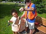 Angler judge Doug Murphy measures the catch of contestant Scarlett in 2023 Art Hansen Memorial Youth Fishing Contest. 